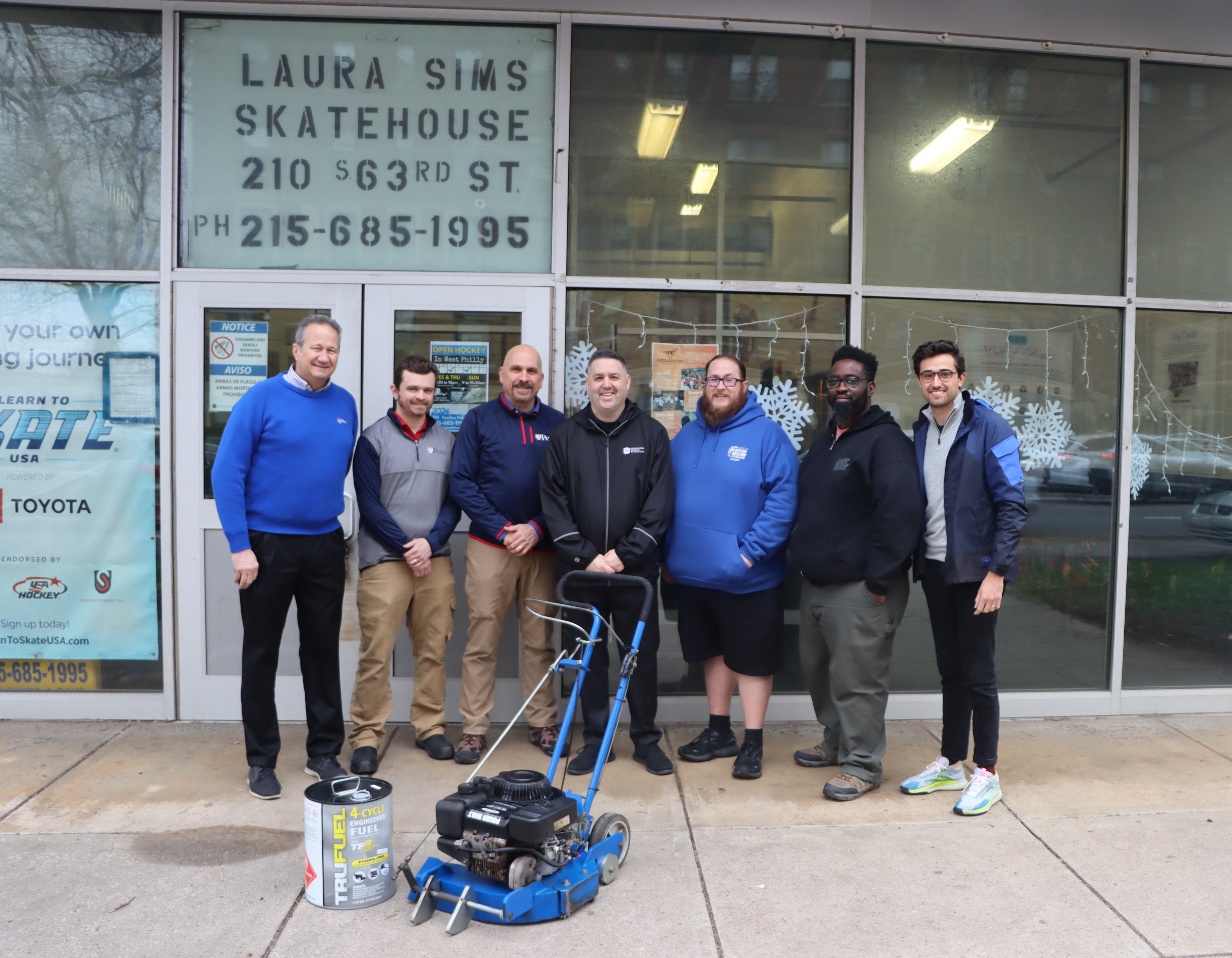 Group standing with ice edger in from of Laura Sims Skate House