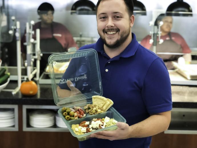 Man holding Penn Green Dining Container