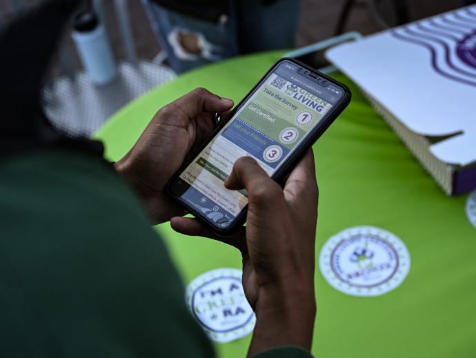 student holding cell phone with app showing