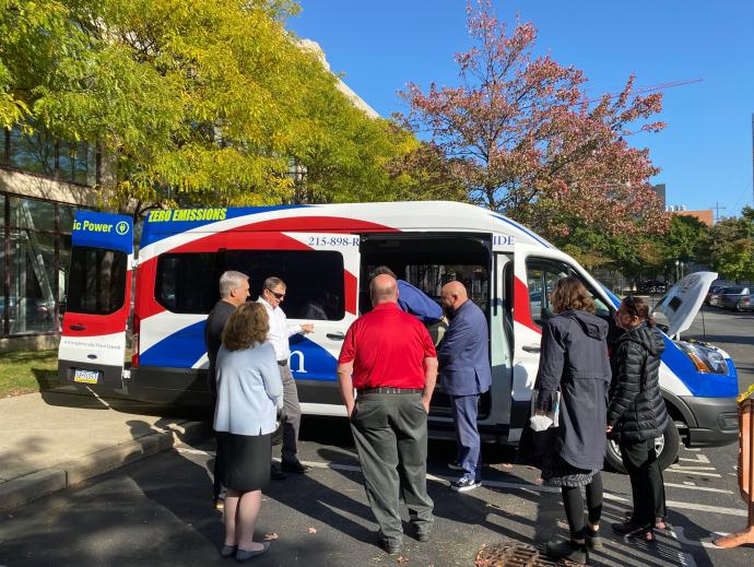 group viewing new EV van