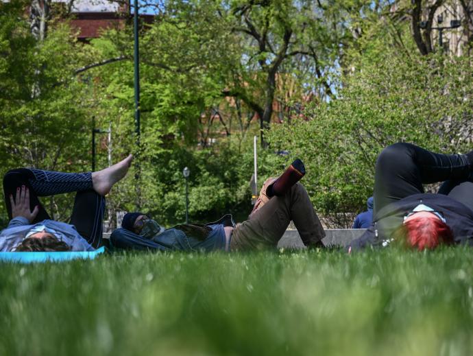 Students rest on the grass in the park.