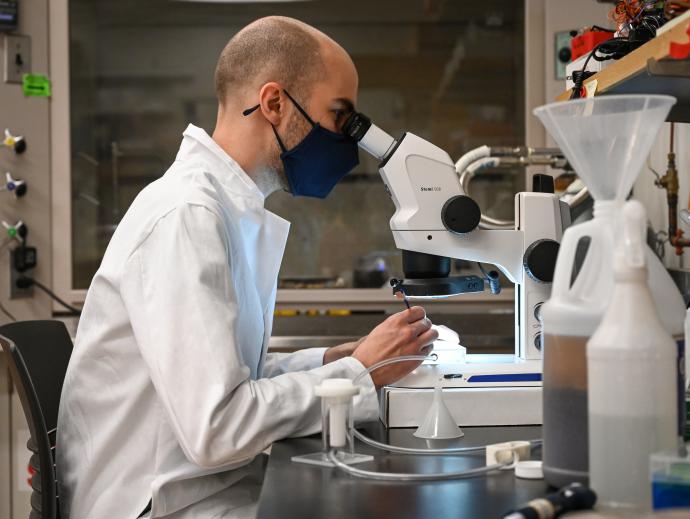 man at microscope in white jacket