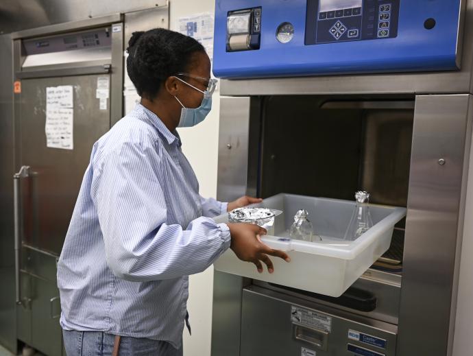 woman in light jacket at faucet with tray