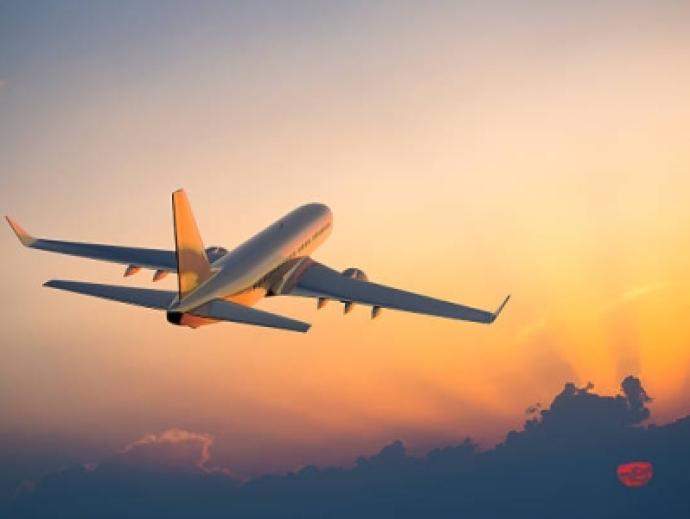 Plane taking off while the sun sets behind clouds